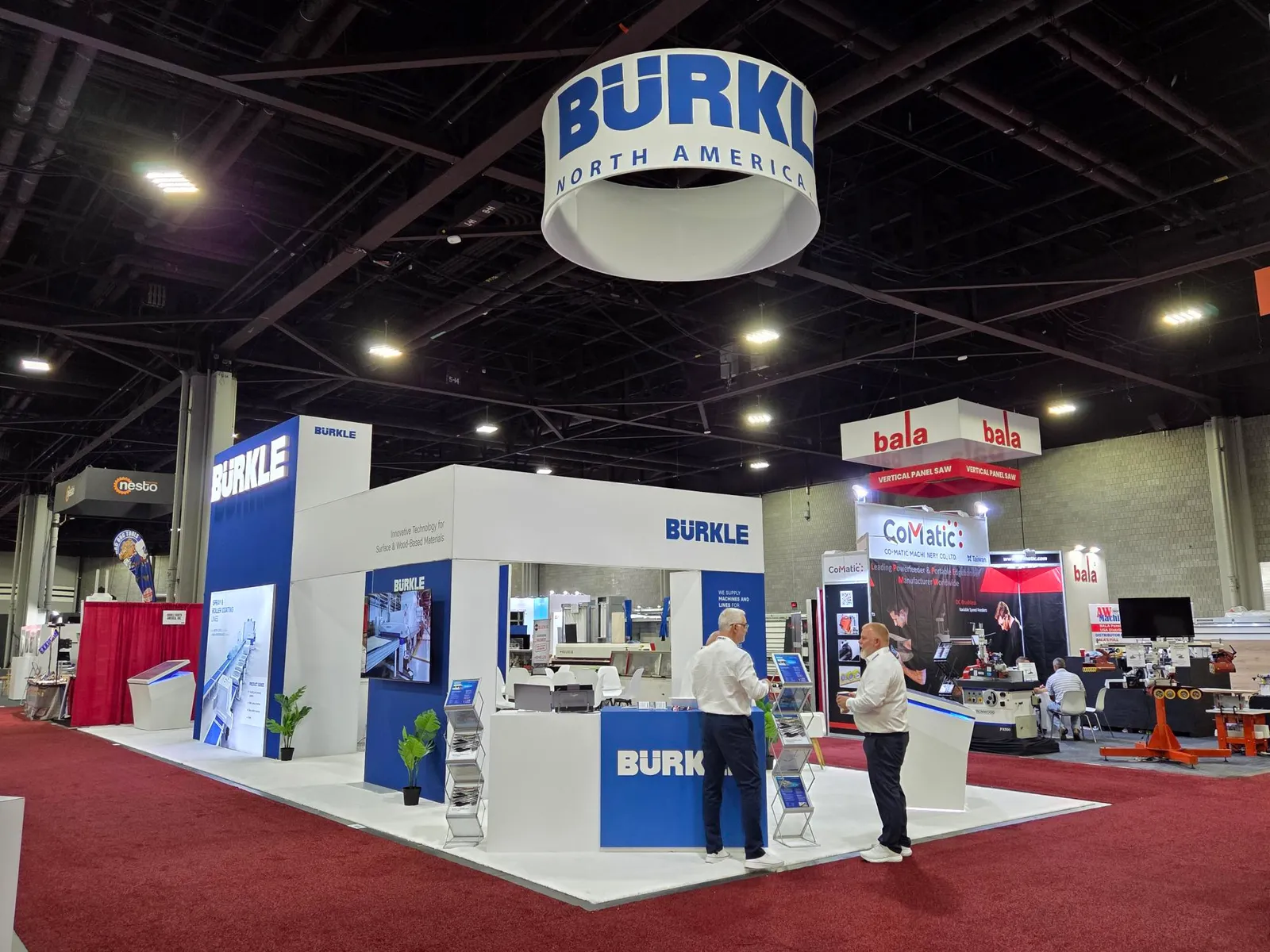 The BÜRKLE North America booth at IWF Atlanta 2026 in Hall B, with a round ceiling banner and a meeting area